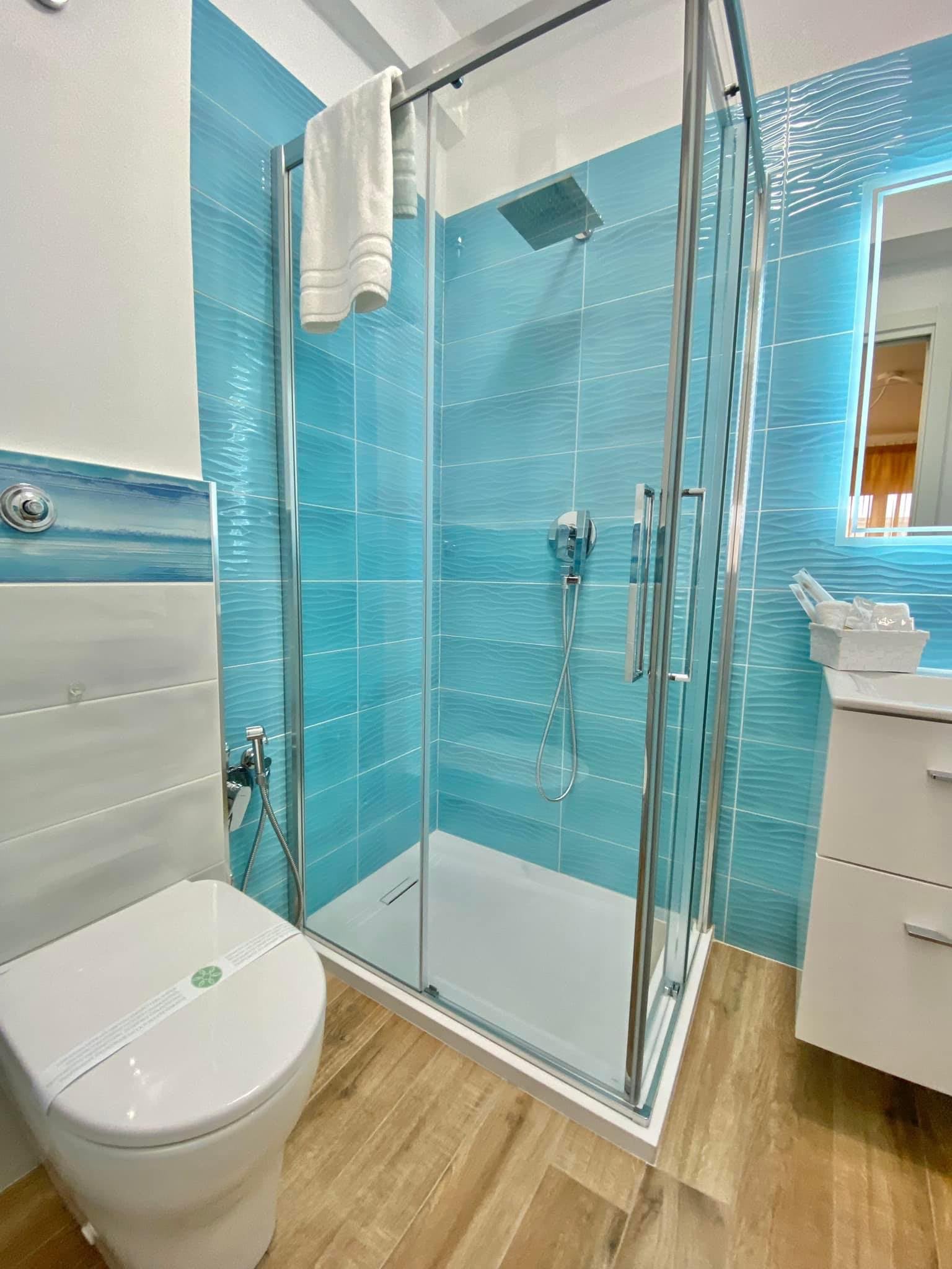 L'Alegria: bagno privato con doccia e piastrelle azzurre a onde