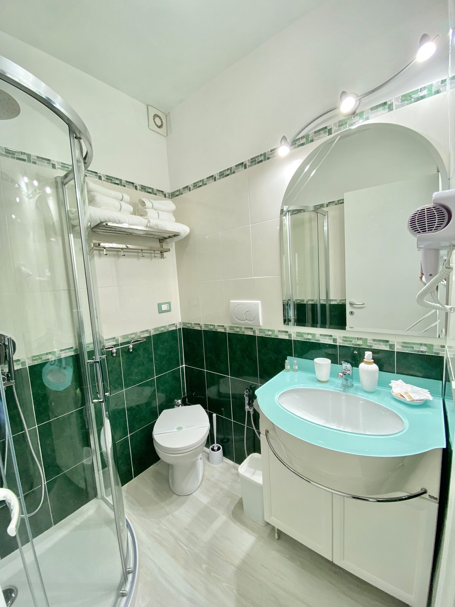 Il bagno de La Esperanza con doccia, piastrelle verdi e lavabo azzurro