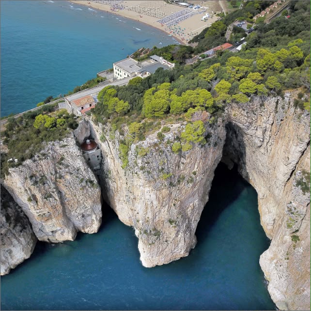 Veduta dall'alto della Montagna Spaccata, con le pareti di roccia sul mare, il santuario e la spiaggia sullo sfondo